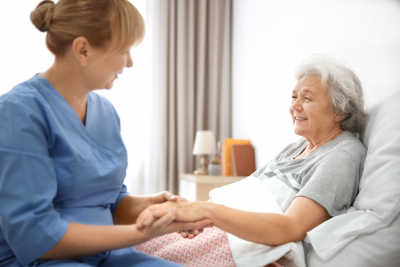 caregiver massaging hand of senior woman